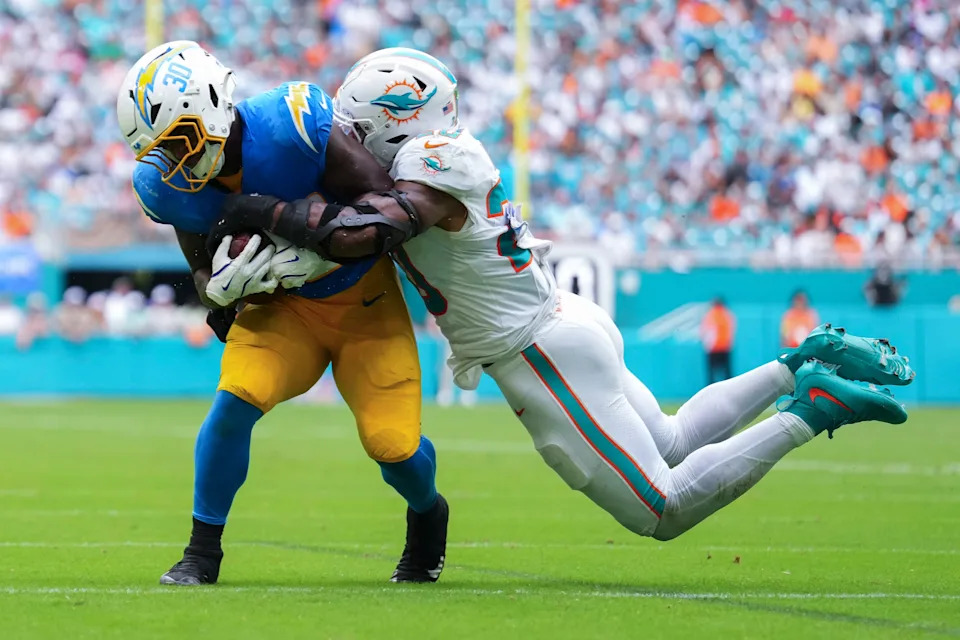 Oct 12, 2025; Miami Gardens, Florida, USA; Miami Dolphins linebacker Jordyn Brooks (20) tackles Los Angeles Chargers running back Kimani Vidal (30) during the third quarter at Hard Rock Stadium. Mandatory Credit: Rich Storry-Imagn Images
