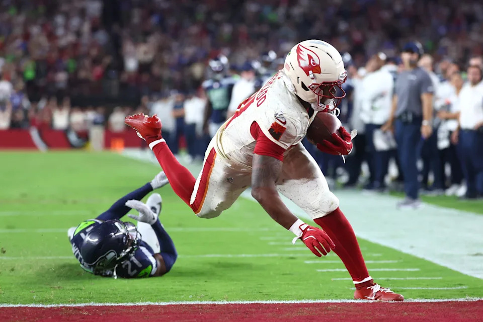 Sep 25, 2025; Glendale, Arizona, USA; Arizona Cardinals running back Emari Demercado (31) runs for a touchdown against Seattle Seahawks cornerback Devon Witherspoon (21) in the fourth quarter at State Farm Stadium. Mandatory Credit: Mark J. Rebilas-Imagn Images