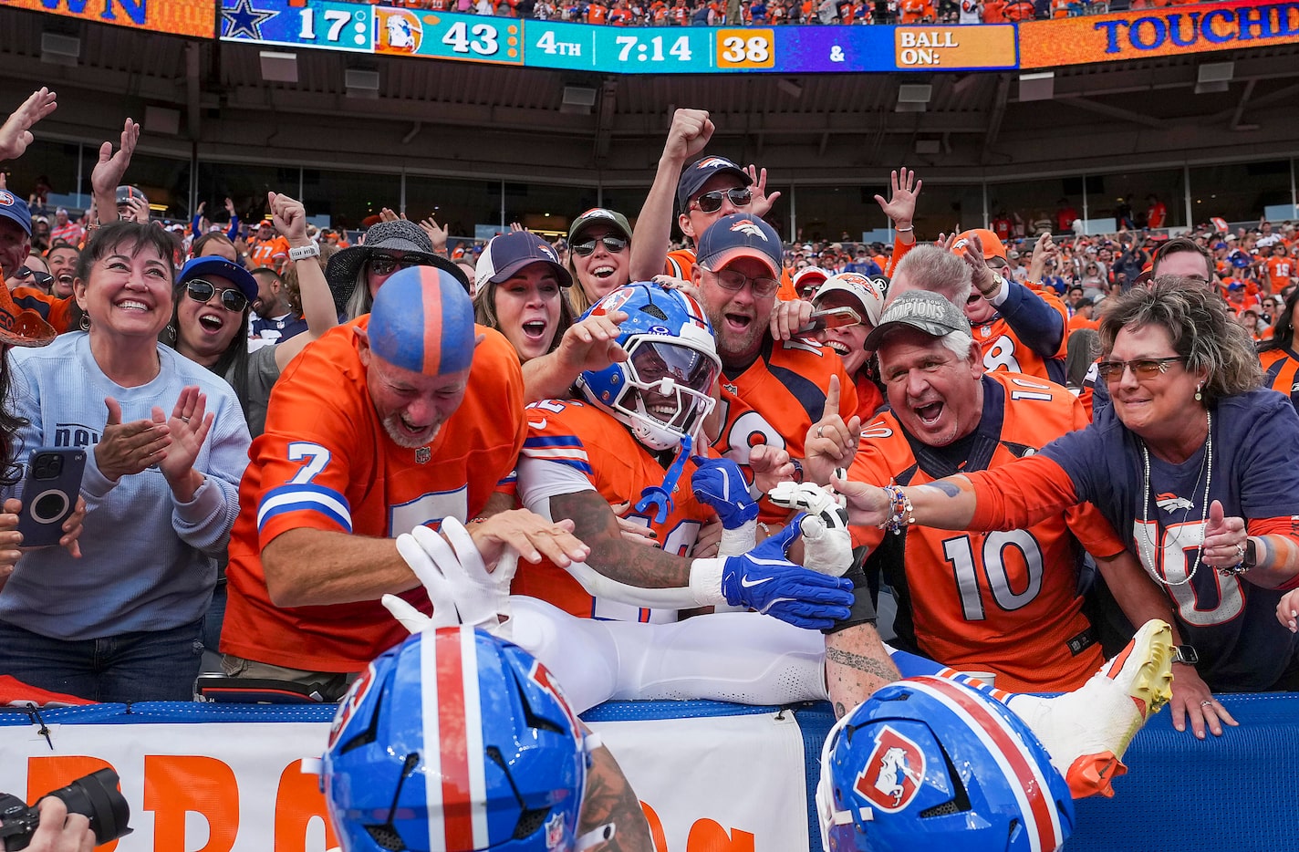 Denver Broncos running back RJ Harvey (12) celebrates with fans after scoring on a touchdown...
