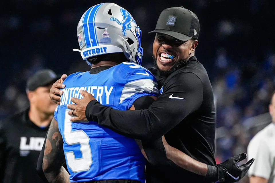 Detroit Lions running backs coach Tashard Rice hugs running back David Montgomery