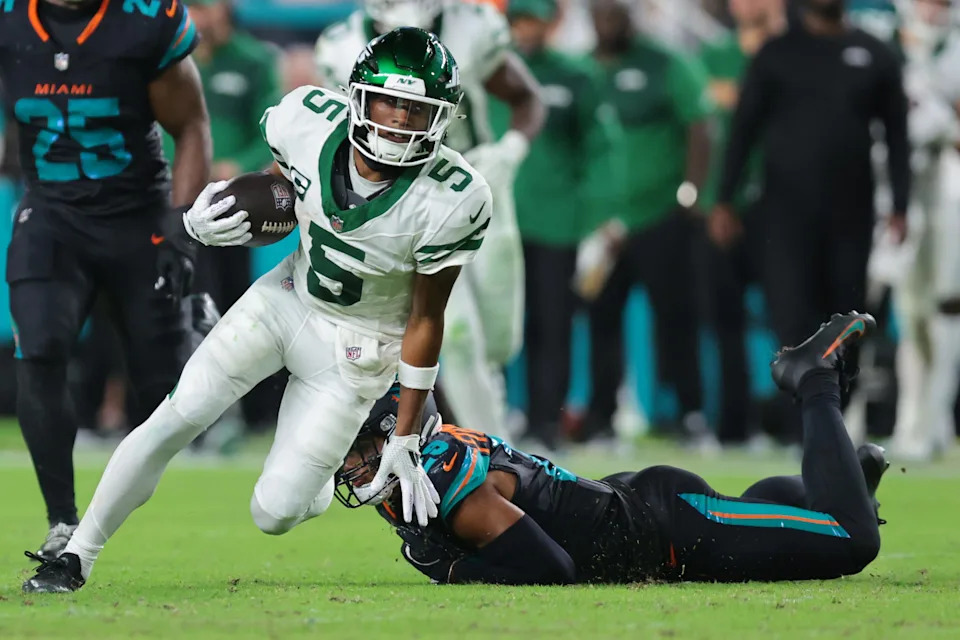 Sep 29, 2025; Miami Gardens, Florida, USA; New York Jets wide receiver Garrett Wilson (5) makes a catch past Miami Dolphins cornerback Artie Burns (23) during the second half at Hard Rock Stadium. Mandatory Credit: Sam Navarro-Imagn Images