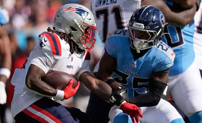 New England Patriots running back Rhamondre Stevenson (38) runs past Tennessee Titans free safety Xavier Woods (25) during the second half of an NFL football game, Sunday, Oct. 19, 2025, in Nashville, Tenn. (AP Photo/George Walker IV)