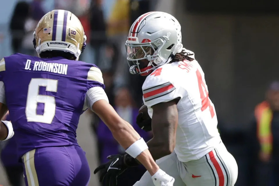 Sep 27, 2025; Seattle, Washington, USA; Ohio State Buckeyes wide receiver Jeremiah Smith (4) runs for yards after the catch against Washington Huskies cornerback Dylan Robinson (6) during the first quarter at Husky Stadium. Mandatory Credit: Joe Nicholson-Imagn Images