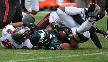 Philadelphia Eagles running back Saquon Barkley (26) is tackled by Tampa Bay Buccaneers linebacker Sirvocea Dennis (8) and safety Tykee Smith (23) during the second half of an NFL football game Sunday, Sept. 28, 2025, in Tampa, Fla. (AP Photo/Jason Behnken)