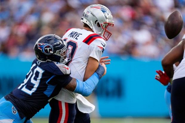 Tennessee Titans linebacker Arden Key (49) sacks New England Patriots quarterback Drake Maye (10) and causing a fumble during the second half of an NFL football game in Nashville, Tenn., Sunday, Nov. 3, 2024. (AP Photo/George Walker IV)