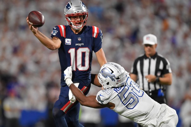 New England Patriots quarterback Drake Maye (10) is pressured by Buffalo Bills defensive end Greg Rousseau (50) during the first half of an NFL football game, Sunday, Sept. 5, 2025, in Orchard Park, N.Y. (AP Photo/Adrian Kraus)