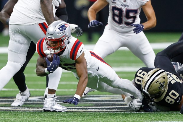 New England Patriots running back Treveyon Henderson is tackled by New Orleans Saints defensive tackle Bryan Bresee during the first half of an NFL football game, Sunday, Oct. 12, 2025, in New Orleans. (AP Photo/Butch Dill)