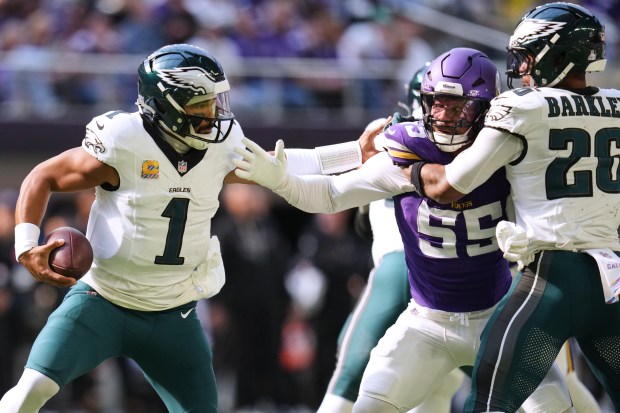 Philadelphia Eagles quarterback Jalen Hurts (1) tries to avoid a tackle from Minnesota Vikings linebacker Eric Wilson (55) during the first half of an NFL football game Sunday, Oct. 19, 2025, in Minneapolis. (AP Photo/Abbie Parr)