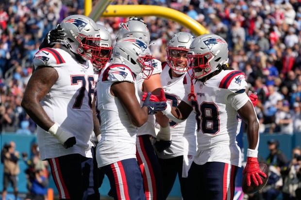 New England Patriots running back Rhamondre Stevenson (38) celebrates a touchdown with teammates during the second half of an NFL football game against the Tennessee Titans, Sunday, Oct. 19, 2025, in Nashville, Tenn. (AP Photo/George Walker IV)