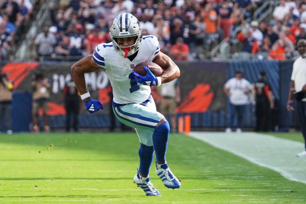 Jalen Tolbert in a white Dallas Cowboys uniform with the number 1, running with a football.