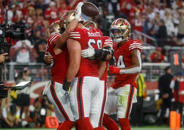 San Francisco 49ers' Christian McCaffrey (23) is congratulated by teammates, including San Francisco 49ers' Colton McKivitz (68), after scoring a touchdown against the Atlanta Falcons in the second quarter at Levi's Stadium in Santa Clara, Calif., on Sunday, Oct. 19, 2025. (Nhat V. Meyer/Bay Area News Group)