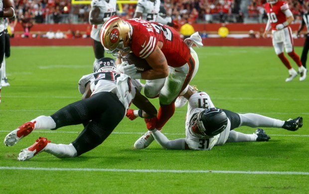 San Francisco 49ers' Christian McCaffrey (23) is stopped short of the goal line by Atlanta Falcons' Dee Alford (20) and Atlanta Falcons' Xavier Watts (31) in the second quarter at Levi's Stadium in Santa Clara, Calif., on Sunday, Oct. 19, 2025. (Nhat V. Meyer/Bay Area News Group)
