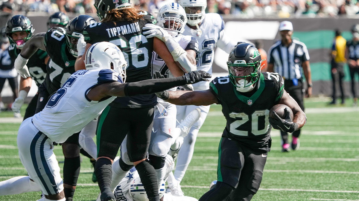 New York Jets running back Breece Hall (20) carries the ball as he works around Dallas Cowboys safety Donovan Wilson (6) during the first half at MetLife Stadium.
