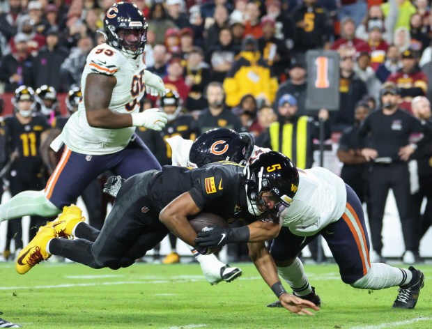 Commanders quarterback Jayden Daniels (5) is tackled by Bears linebacker...