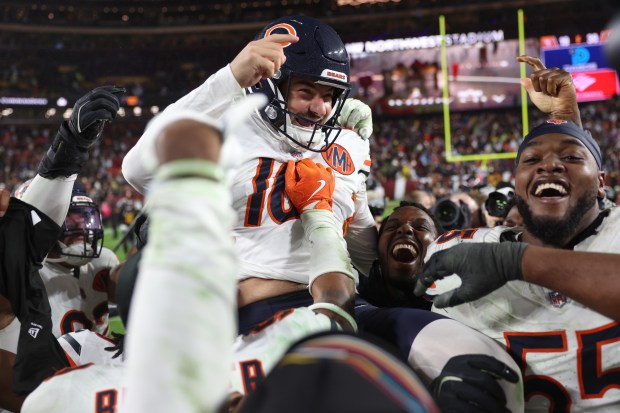 Bears kicker Jake Moody is hoisted by teammates after kicking...