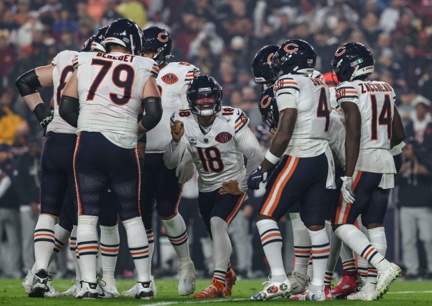 Bears quarterback Caleb Williams (18) runs the huddle against the...
