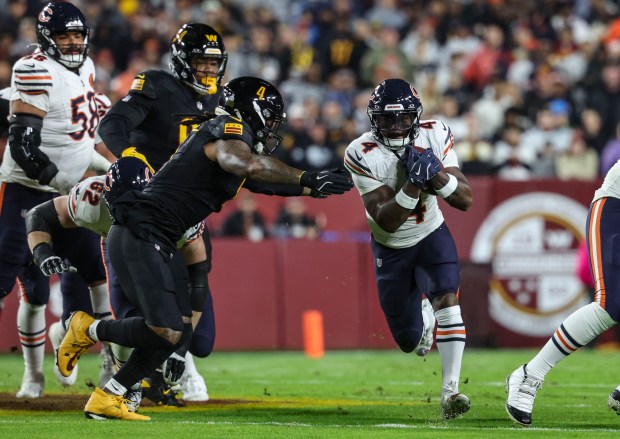 Chicago Bears running back D'Andre Swift runs the ball ahead...