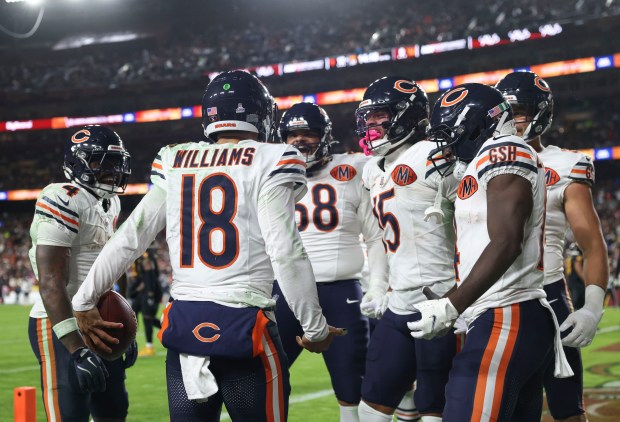 Chicago Bears quarterback Caleb Williams celebrates with teammates after scoring...