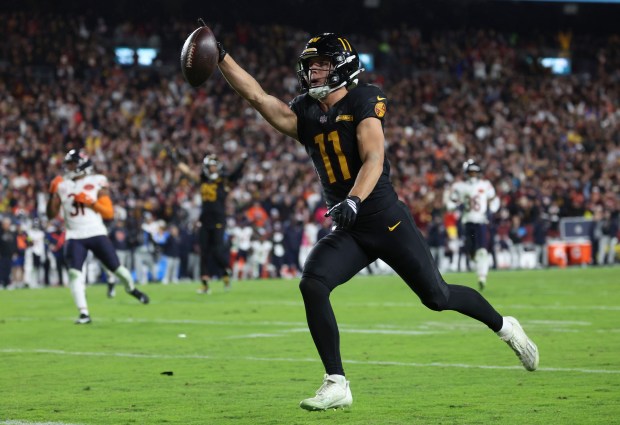 Washington Commanders wide receiver Luke McCaffrey (11) catches a long...