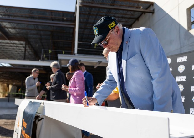 Bedford Park Village President David Brady signs the final beam...