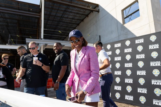 Chicago Sky co-owner and operating chairman Nadia Rawlinson, center, signs...