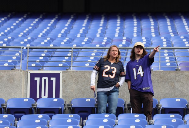 A Bears fan and a Ravens fan take in the scene at M&T Bank Stadium in Baltimore as players warm up Sunday, Oct. 26, 2025. (Chris Sweda/Chicago Tribune)