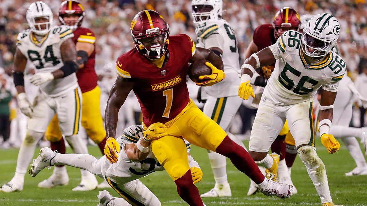 Washington Commanders wide receiver Deebo Samuel (1) breaks a tackle by Green Bay Packers safety Evan Williams (33) to score a touchdown on Thursday, September 11, 2025, at Lambeau Field in Green Bay, Wis