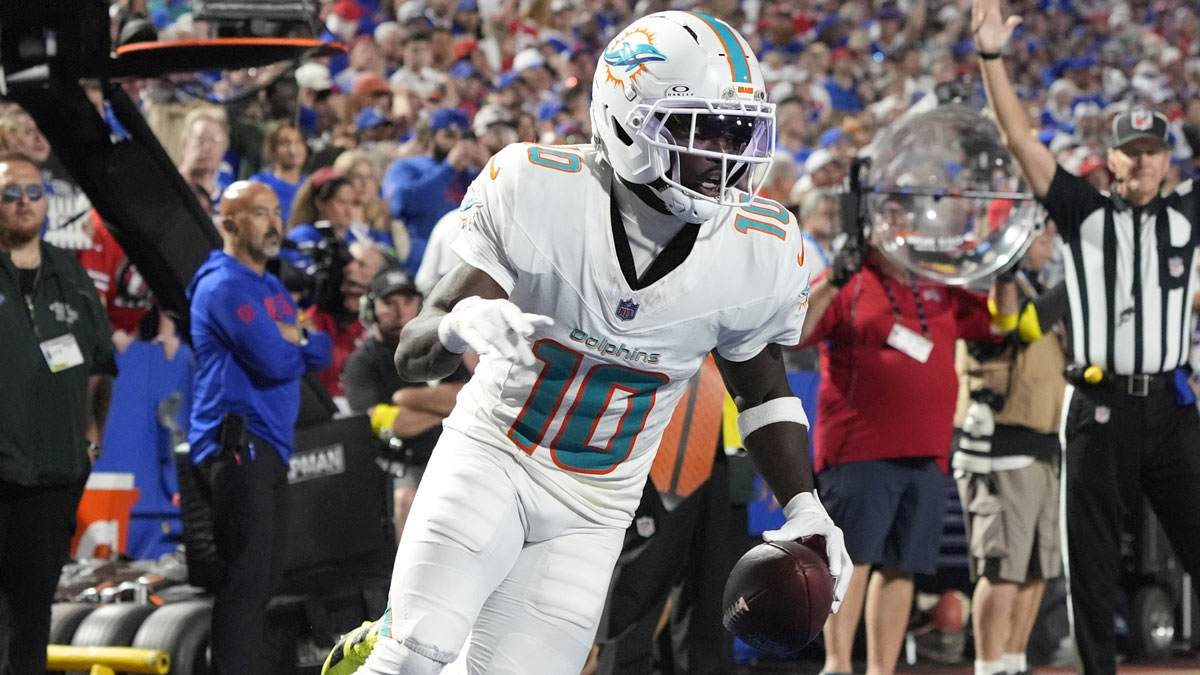 Dolphins wide receiver Tyreek Hill (10) scores a touchdown against the Buffalo Bills in the fourth quarter at Highmark Stadium with Stephen A Smith in the background