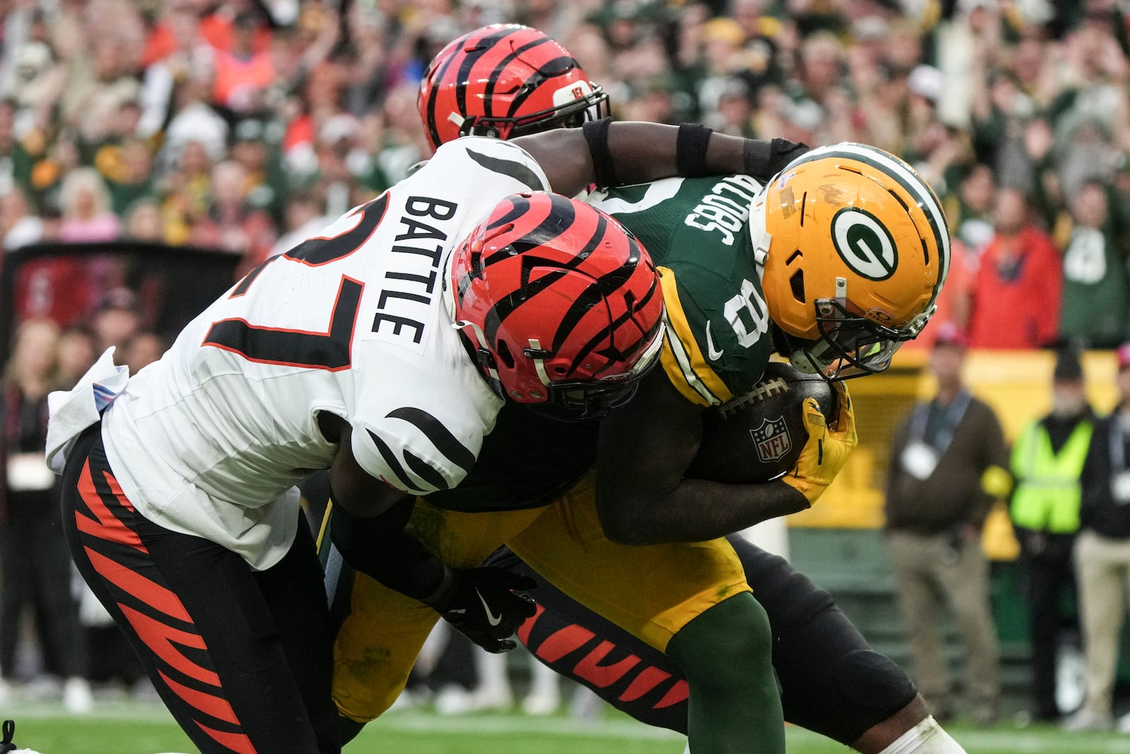 Green Bay Packers running back Josh Jacobs (8) scores a touchdown against Cincinnati Bengals safety Jordan Battle (27) in the second half of an NFL football game, Sunday, Oct. 12, 2025, in Green Bay, Wis. (AP Photo/Morry Gash)
