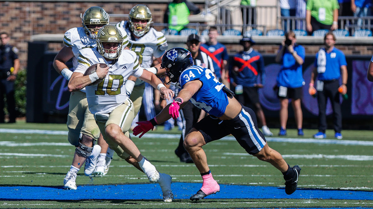 Georgia Tech Yellow Jackets quarterback Haynes King (10) runs with the ball and is defended by Duke Blue Devils linebacker Luke Mergott (34) during the first half of the game at Wallace Wade Stadium.