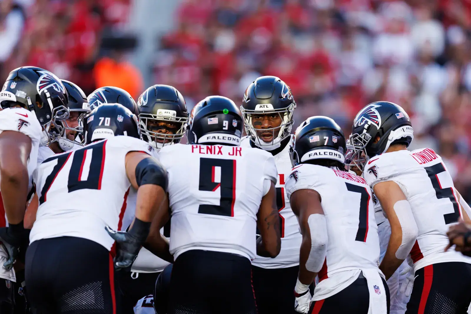 Atlanta Falcons football team huddles on the field.