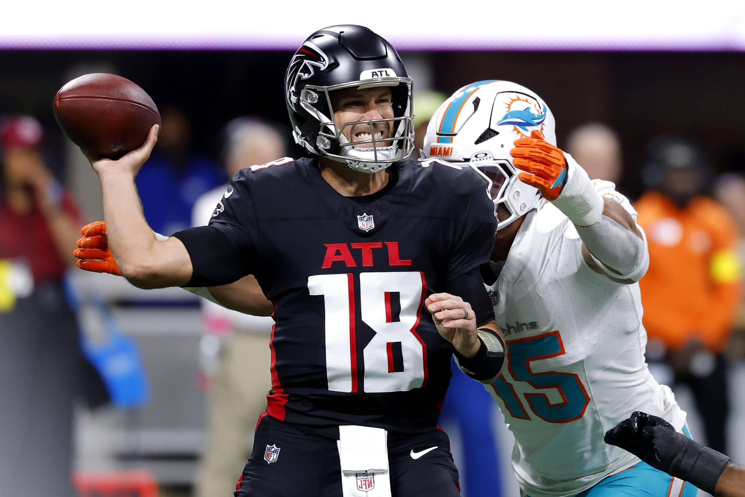 Kirk Cousins is pressured by Jaelan Phillips of the Miami Dolphins as he attempts to pass.