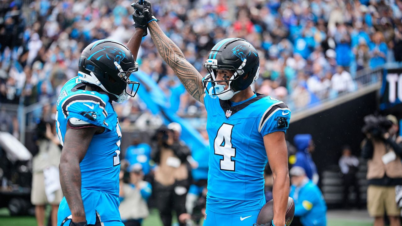 Carolina Panthers receiver Tetairoa McMillan (4) clasped hands with teammate Xavier Legette after McMillan caught his first career touchdown pass in the first half against the Dallas Cowboys in Charlotte, N.C.