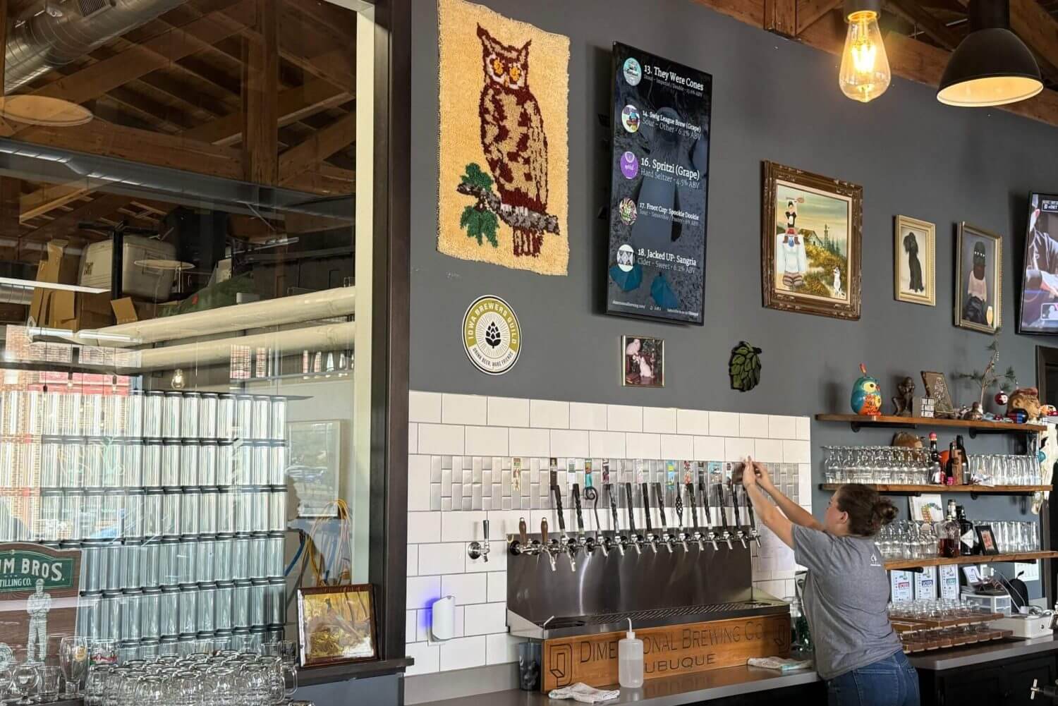 A bartender works the taps at Dimensional Brewing in Dubuque, Iowa, one of the region's many respected beer producers.