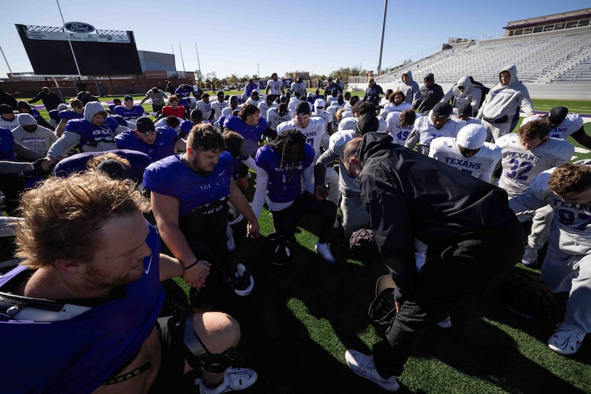 Tarleton State Texans head coach Todd Whitten leads his players in the Lord's Prayer at the...