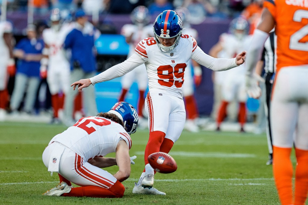 New York Giants kicker Jude McAtamney (99) misses the point after attempt as punter Jamie Gillan (12) holds in the fourth quarter against the Denver Broncos at Empower Field at Mile High. 