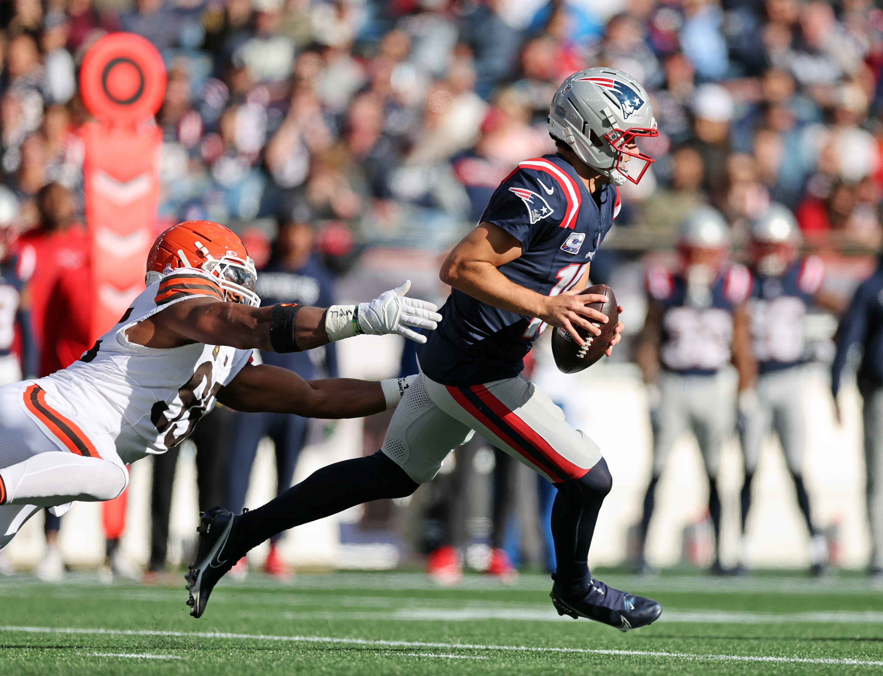 Cleveland Browns defensive end Myles Garrett dives for New England Patriots quarterback Drake Maye, tripping him up in the second half of play. 