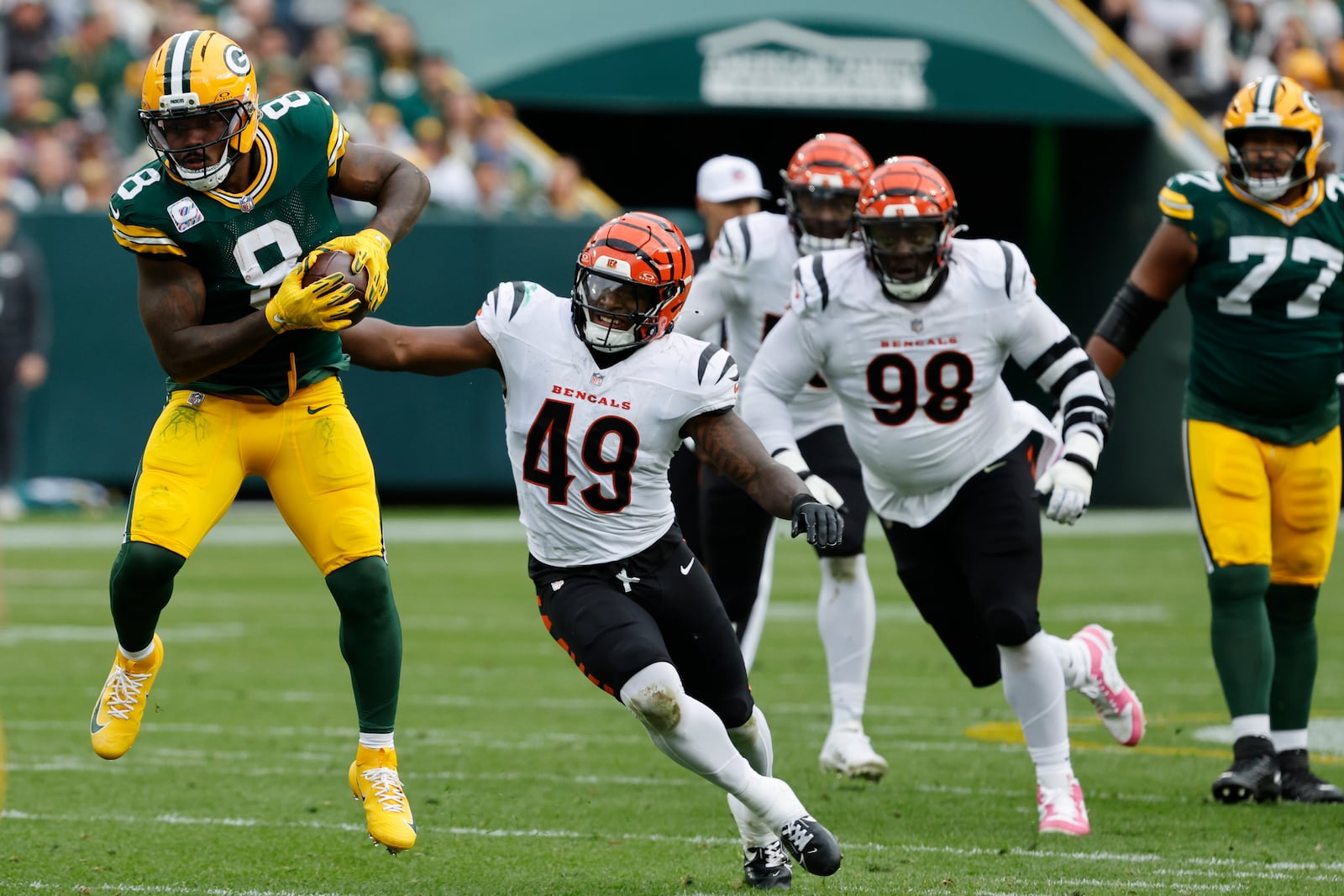 Green Bay Packers running back Josh Jacobs (8) runs against Cincinnati Bengals linebacker Barrett Carter (49) in the first half of an NFL football game, Sunday, Oct. 12, 2025, in Green Bay, Wis. (AP Photo/Mike Roemer)