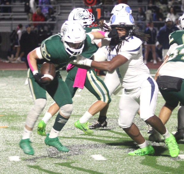 Red Bluff's Cruz Servera (11) tries to escape the grasp...