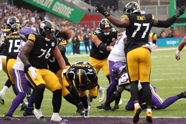 Pittsburgh Steelers running back Kenneth Gainwell (14), centre, scores a touchdown during the NFL football game between Minnesota Vikings and Pittsburgh Steelers at Croke Park stadium in Dublin, Sunday, Sept. 28, 2025.(AP Photo/Peter Morrison)