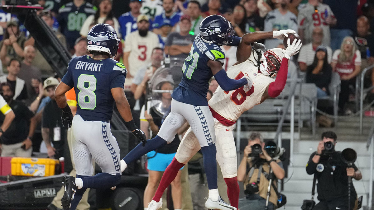 Arizona Cardinals receiver Marvin Harrison Jr. (18) catches a touchdown pass as Seattle Seahawks cornerback Devon Witherspoon (21) defends at State Farm Stadium in Glendale on Sept. 25, 2025.