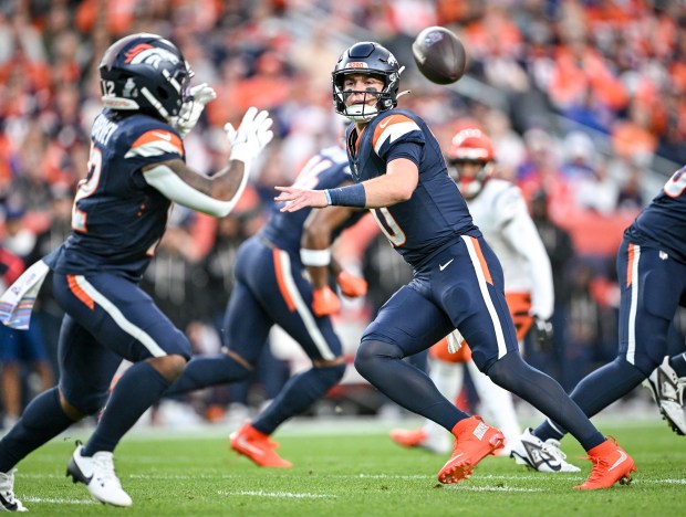 Bo Nix (10) of the Denver Broncos pitches to RJ Harvey (12) during the first quarter against the Cincinnati Bengals at Empower Field at Mile High on Monday, Sept. 29, 2025. (Photo by AAron Ontiveroz/The Denver Post)