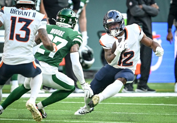 RJ Harvey (12) of the Denver Broncos cuts back as Malachi Moore (27) of the New York Jets lines him up during the second quarter at Tottenham Hotspur Stadium in London on Sunday, Oct. 12, 2025. (Photo by AAron Ontiveroz/The Denver Post)