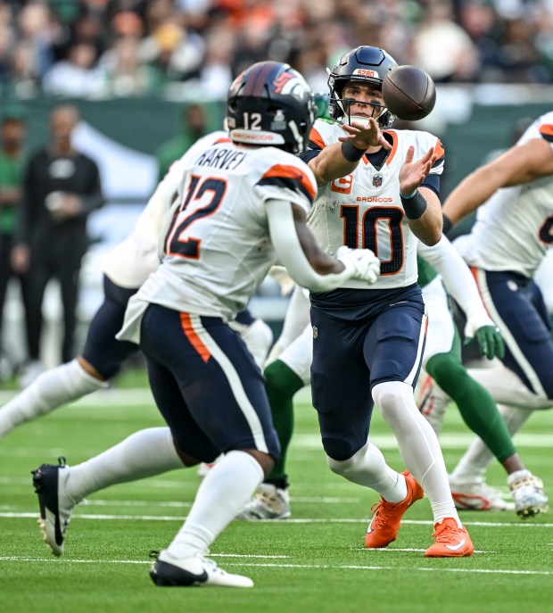 Bo Nix (10) of the Denver Broncos pitches to RJ Harvey (12) during the third quarter against the New York Jets at Tottenham Hotspur Stadium in London on Sunday, Oct. 12, 2025. (Photo by AAron Ontiveroz/The Denver Post)