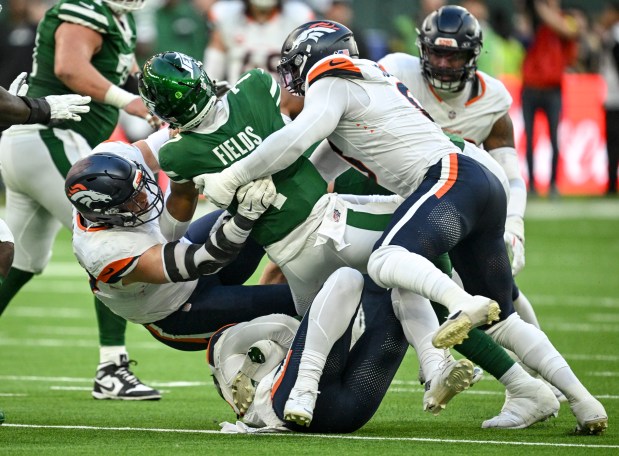 Nik Bonitto (15) of the Denver Broncos sacks Justin Fields (7) of the New York Jets as Zach Allen (99) and Jonathon Cooper (0) provide additional punishment during the fourth quarter of the Broncos' 13-11 win at Tottenham Hotspur Stadium in London on Sunday, Oct. 12, 2025. (Photo by AAron Ontiveroz/The Denver Post)