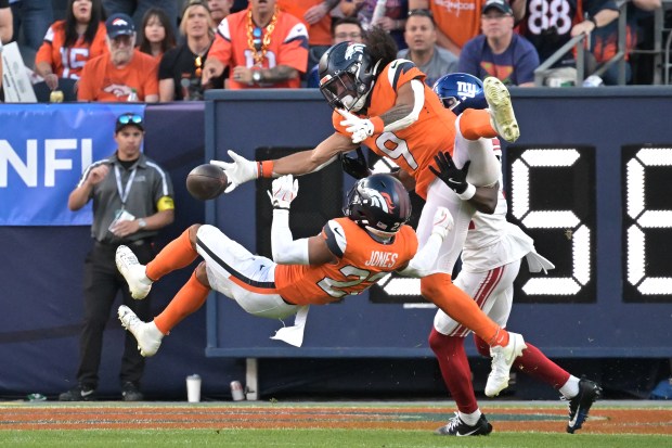 Denver Broncos Brandon Jones (22) and Talanoa Hufanga (9) break...