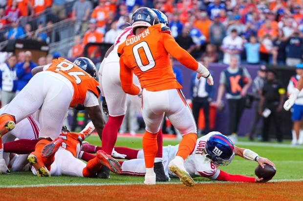 New York Giants quarterback Jaxson Dart (6) reaches for the...