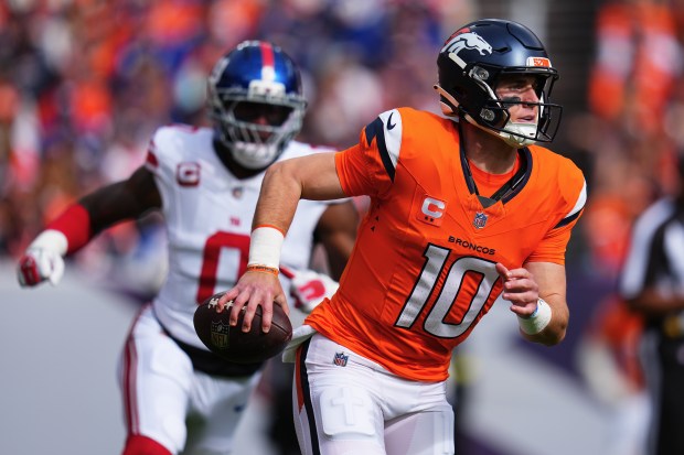 Denver Broncos quarterback Bo Nix (10) rolls out in front...