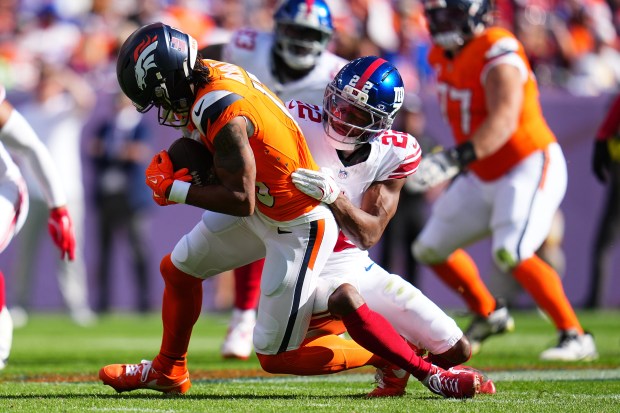Denver Broncos wide receiver Pat Bryant, left, is tackled by...