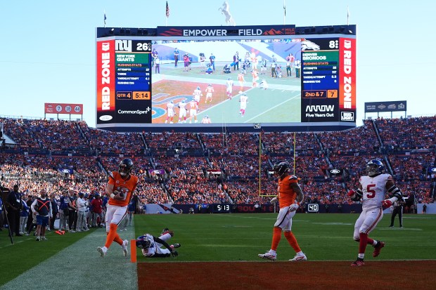 Denver Broncos quarterback Bo Nix, bottom left, scores against the...